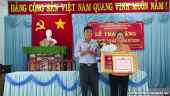 Đ/c Đinh Tấn Hoàng - Tỉnh ủy viên, Bí thư Huyện ủy, Chủ tịch HĐND huyện trao Huy hiệu 50 năm tuổi Đảng cho đồng chí Nguyễn Thị Kim Em.