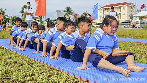 Các em học sinh tiểu học tham gia trò chơi vận động ngoài trời