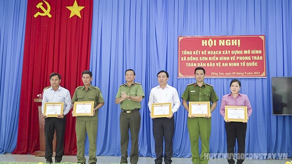 Anh Phan Văn Đẹp (bìa trái) nhận giấy khen tại Hội nghị tổng kết Phong trào Toàn dân bảo vệ an ninh Tổ quốc xã Đồng Sơn