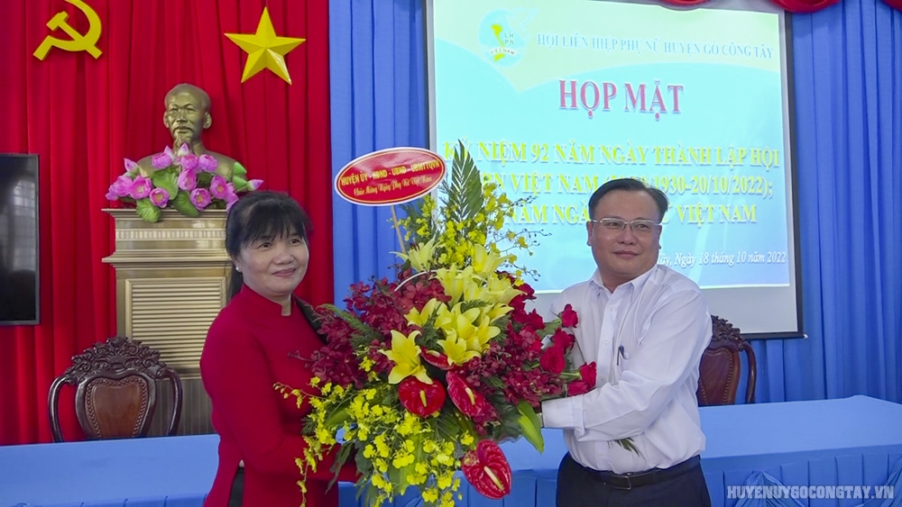 Đ/c Phạm Nguyễn Hoàng Vũ - Phó Bí thư Thường trực Huyện ủy tặng hoa chúc mừng Họp mặt kỷ niệm