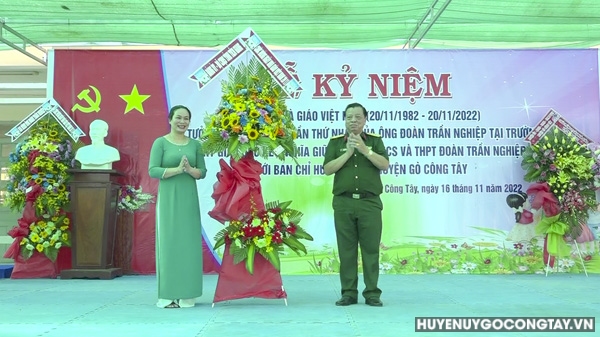 Đại tá Huỳnh Ngọc Huệ - Phó Chính ủy Bộ Chỉ huy Quân sự tỉnh Tiền Giang tặng hoa lưu niệm cho nhà trường