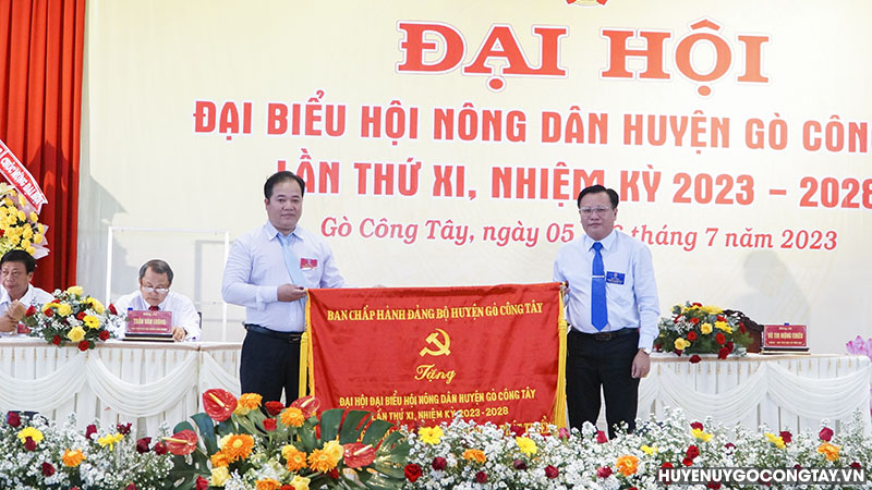 Ông Phạm Nguyễn Hoàng Vũ - Phó Bí thư Thường trực Huyện ủy trao bức trướng của Ban Chấp hành Đảng bộ huyện
