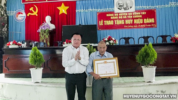 Đ/c Phạm Nguyễn Hoàng Vũ - Phó Bí thư Thường trực Huyện ủy trao Huy hiệu 55 tuổi đảng cho đảng viên thuộc Đảng bộ xã Yên Luông.