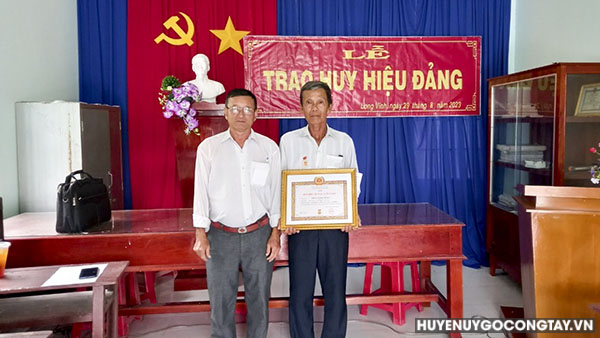 Đồng chí Đặng Công Tiên – Bí thư Đảng ủy xã Long Vĩnh trao Huy hiệu Đảng cho đồng chí Trần Văn Dũng.
